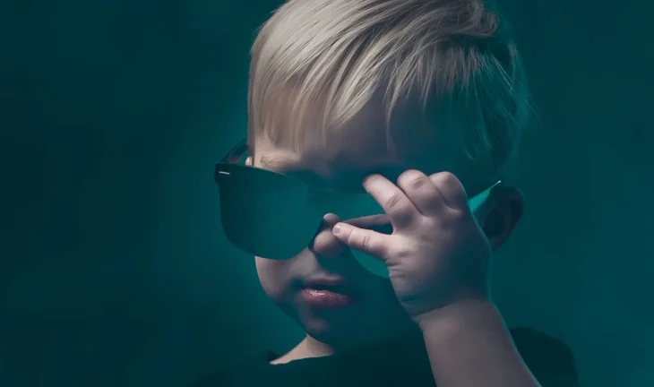 a blonde haired child in sunglasses